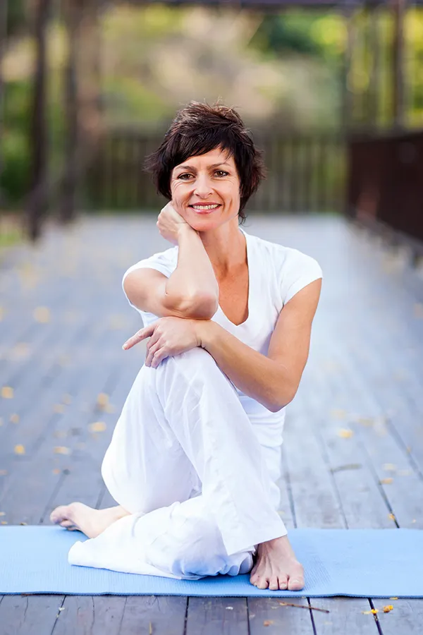 BCAA-Vitamin-Injection-Treatment A middle-aged woman sits on a yoga mat. Get BCAA Vitamin Injection treatment from Christine Collins, MD in Westside/Beverly Hills.