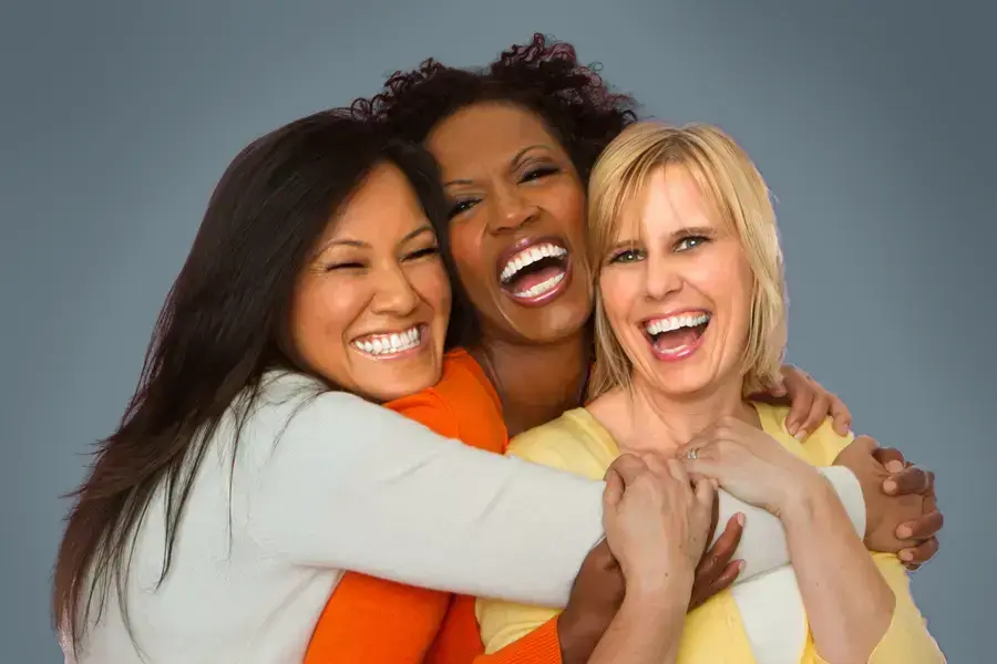 Bioidentical-Hormone-Pellet-Therapy-for-Women-Clinic Three joyful women embracing in a group hug, laughing and smiling after receiving Bioidentical Hormone Pellet Therapy by Christine Collins, MD in Westside/Beverly Hills.