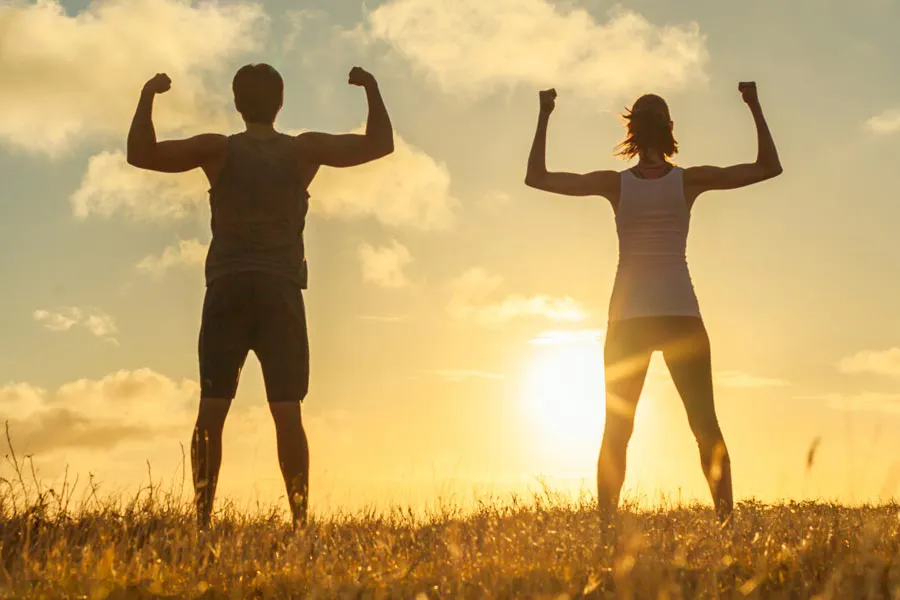 Immune-Boost-Injections-Clinic A couple flex their raised arms in the sunset. Schedule Tri-Immune Boost Injection treatments from Christine Collins, MD in Westside/Beverly Hills.