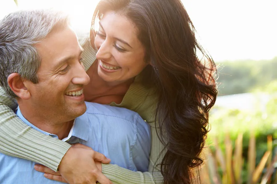 Longevity-Medicine-Clinic A latin couple embrace in a sunny meadow. Get longevity medicine treatment from Christine Collins, MD in Westside/Beverly Hills.