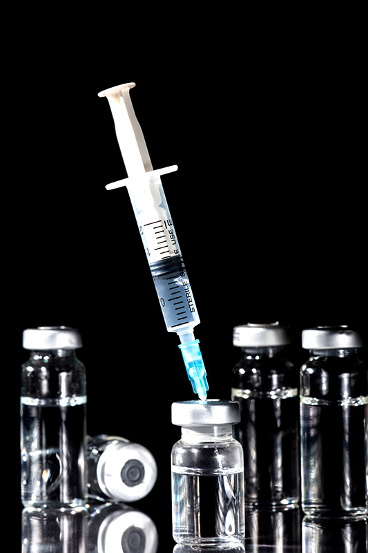 NAD-Injection-Treatment Close-up of a syringe piercing a vial of fluid. Get NAD+ injections from Christine Collins, MD in Westside/Beverly Hills.