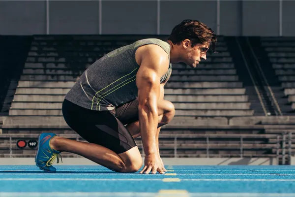 Performance-Recovery-IV-Therapy-Clinic A strong man gets ready to race at the starting line of a track. Schedule IV Therapy for performance recovery relief from Christine Collins, MD in Westside/Beverly Hills.